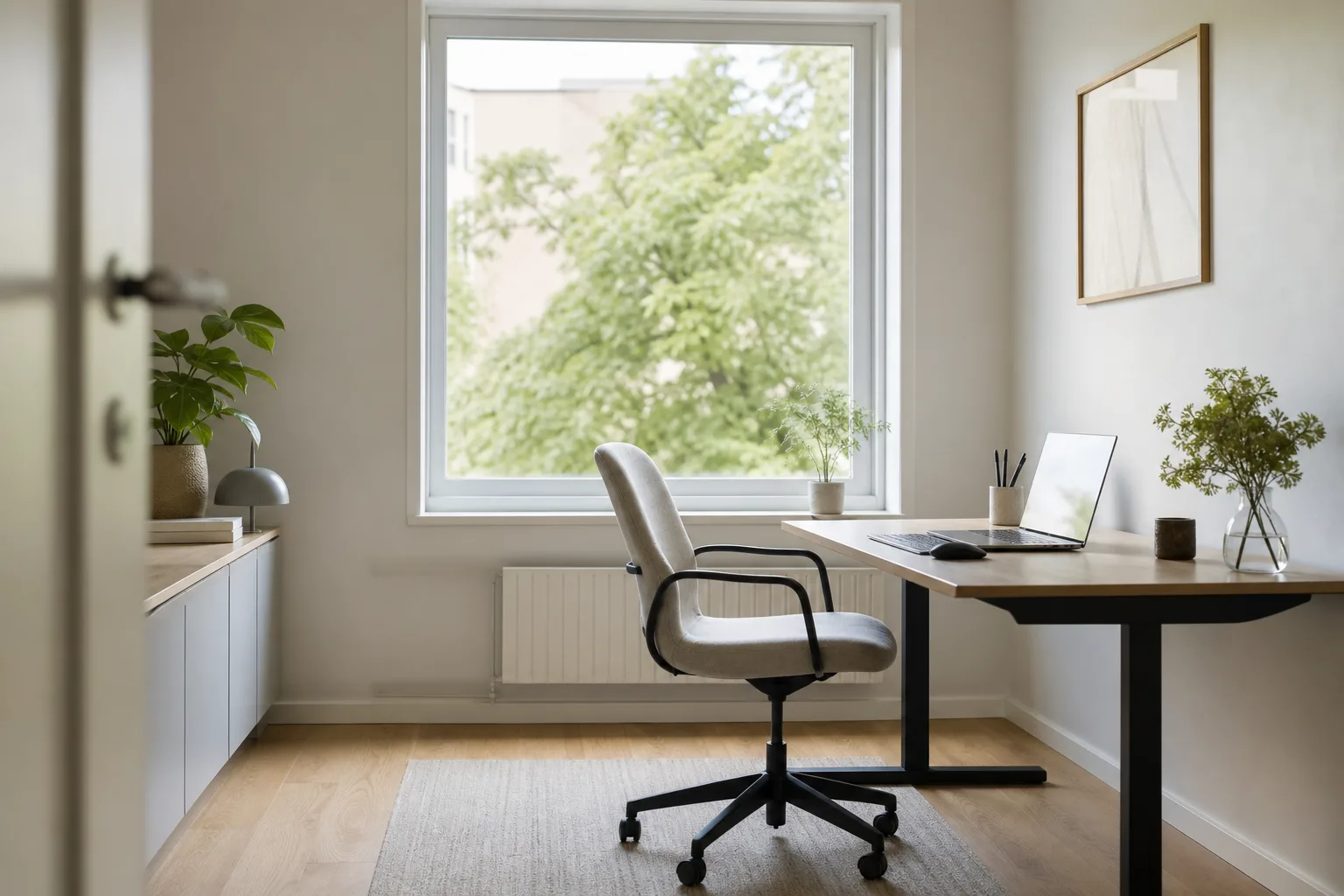 Ett svenskt hemmakontor nystädat med skrivbord och stol i ordning och mjukt dagsljus genom fönstret
